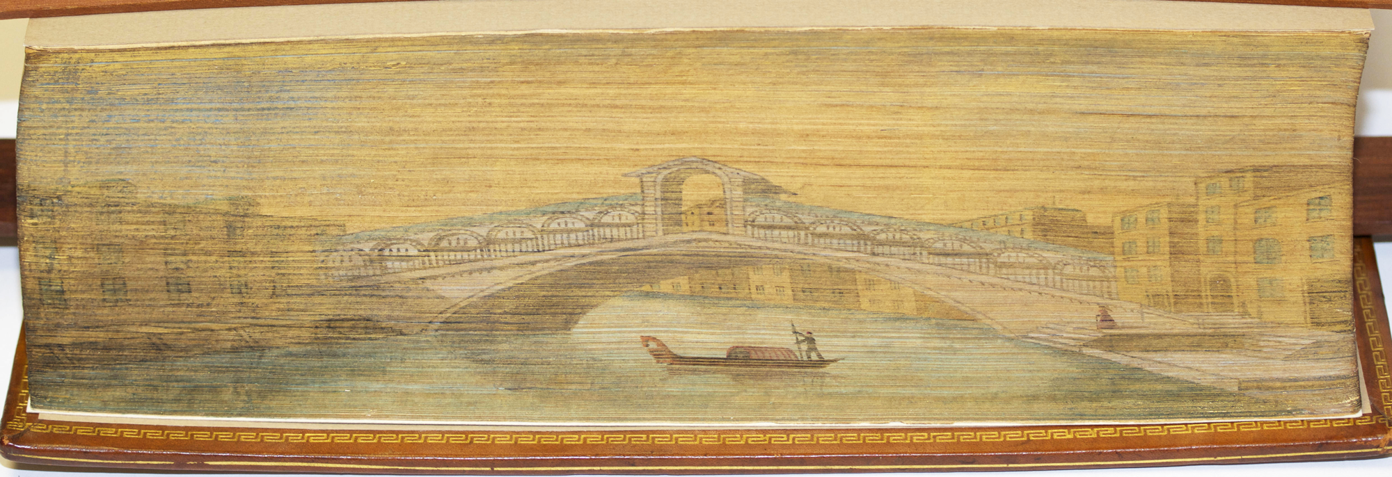 Fore-edge painting on book of bridge, river and gondola.