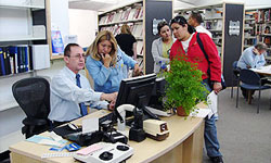 Photo of Branch Manager assisting library patrons at Mission Valley Branch Library in locating library materials