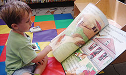 Photo of little boy fascinated with a big book at Central Library