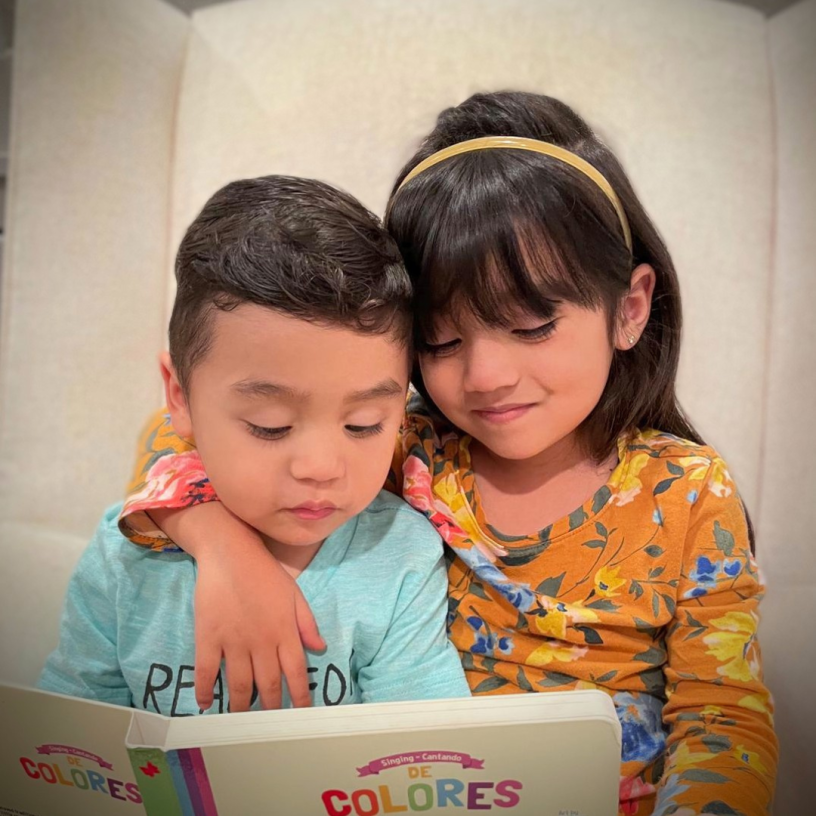 Two kids reading a book together