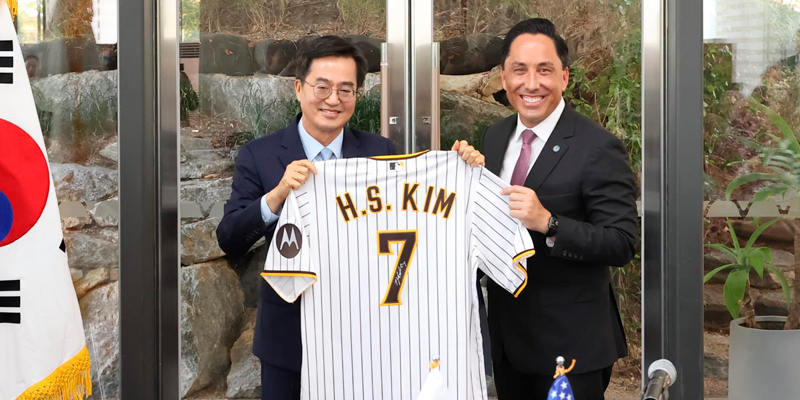 Governor Dong Yeon Kim and Mayor Todd Gloria holding a Ha-Seong Kim Padres jersey