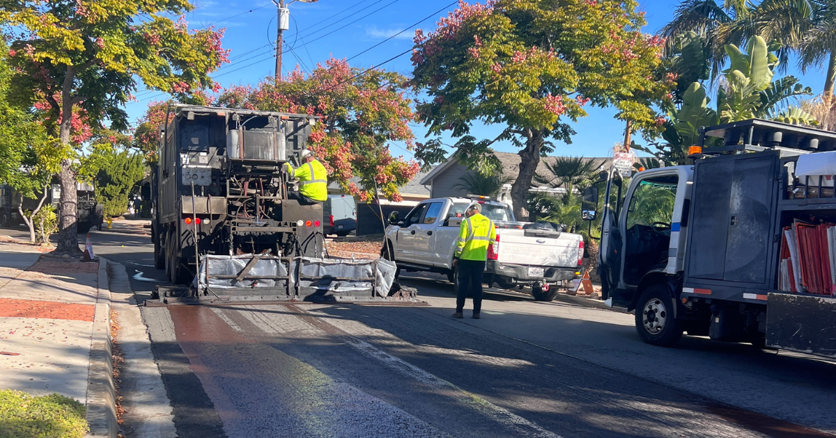 street crews working on a vehicle to slurry seal a road in san diego