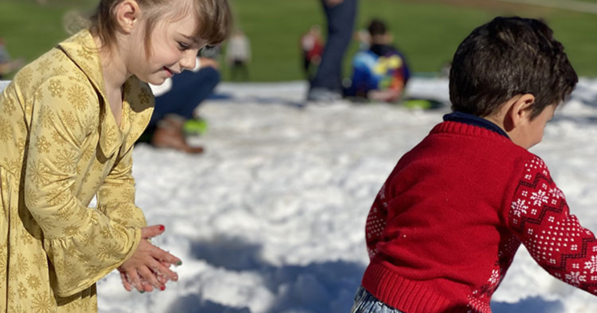 two children playing in snow at a Parks & Recreation winter festival