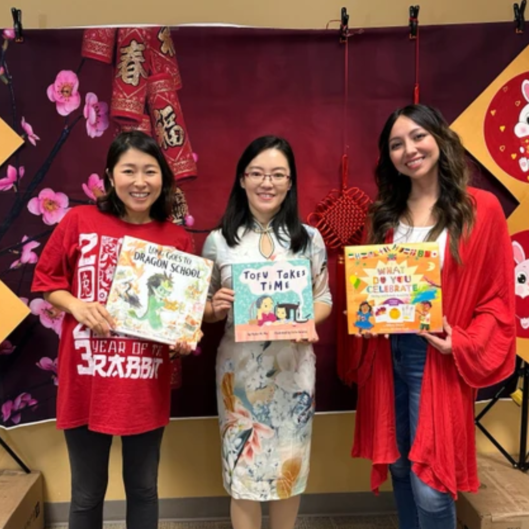 Author Helen Wu posing with her picture book and staff members posing with Lunar New Year picture books