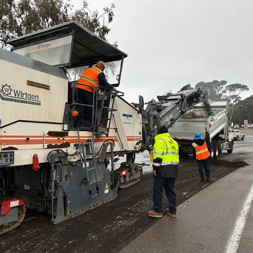 City workers fixing a road with asphalt overlay