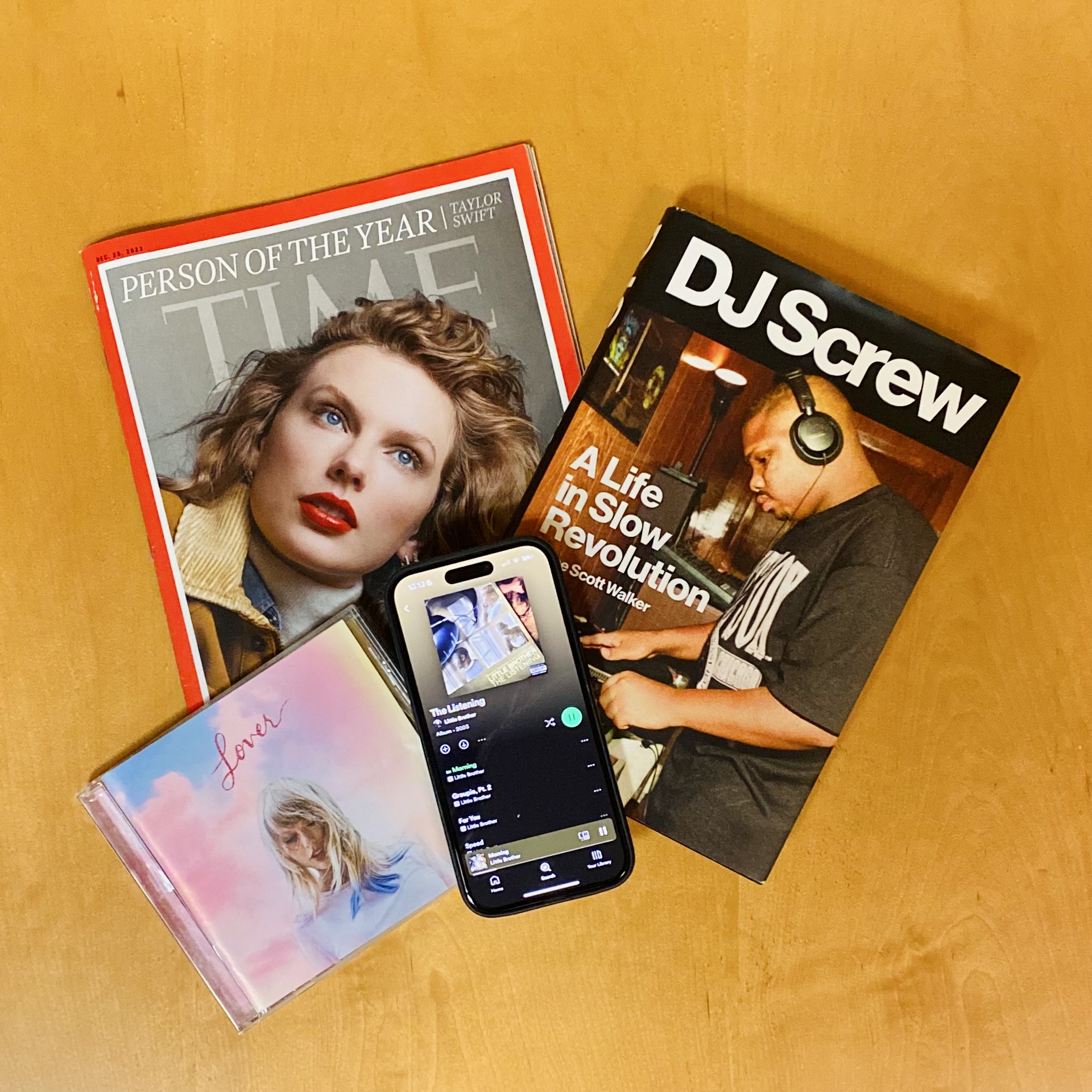 Time cover featuring Person of the year, Taylor Swift; CD case of Taylor Swift album Lover; book cover of DJ Screw: A Life of Slow Revolution; iPhone open to the Spotify app
