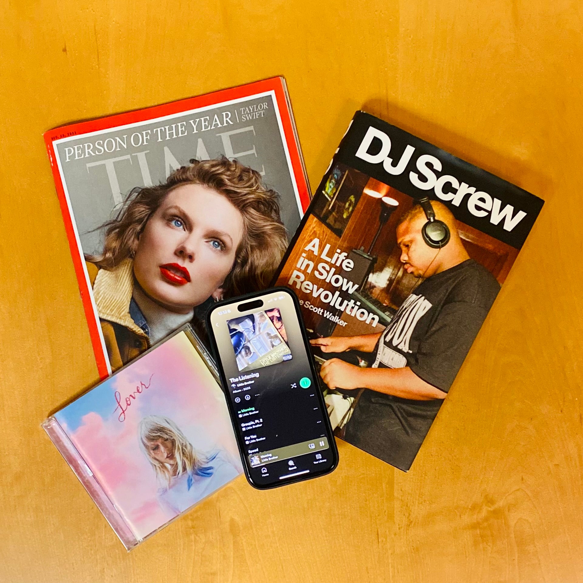 Time cover featuring Person of the year, Taylor Swift; CD case of Taylor Swift album Lover; book cover of DJ Screw: A Life of Slow Revolution; iPhone open to the Spotify app