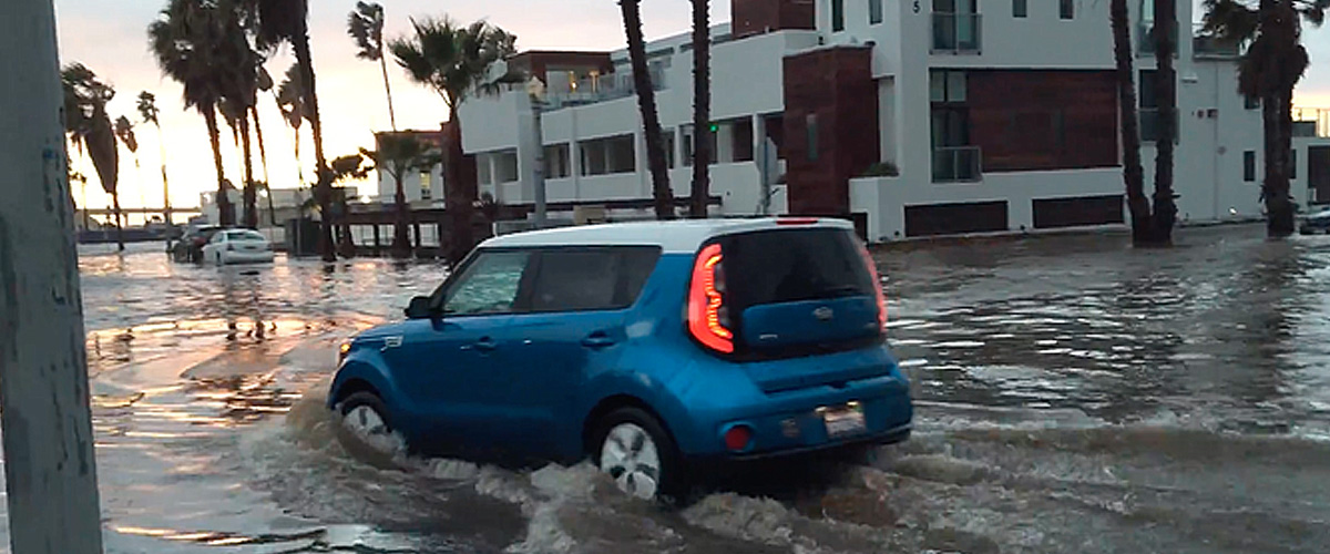 A car driving through a flooded street in Ocean Beach