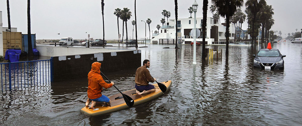 A couple of residents kayaking on a flooded street in Ocean Beach
