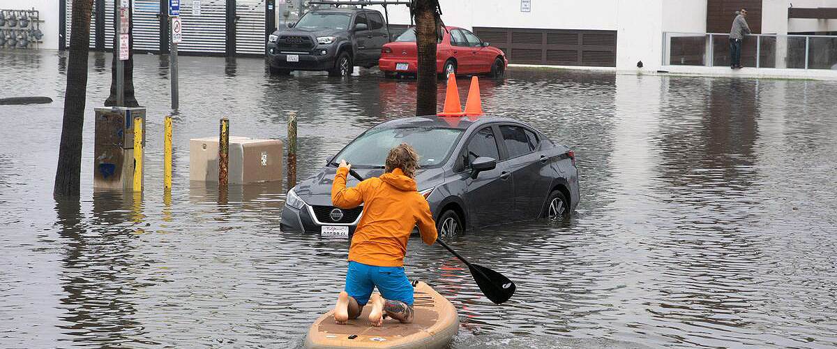 A resident kayaking on a flooded street in Ocean Beach