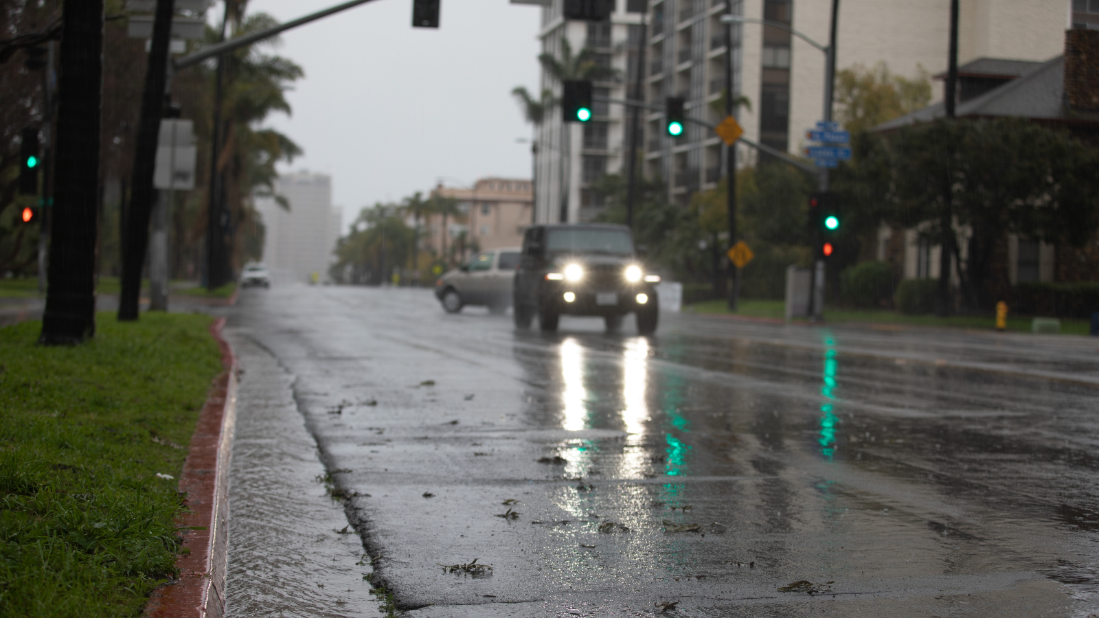 a jeep driving on a wet street from rain