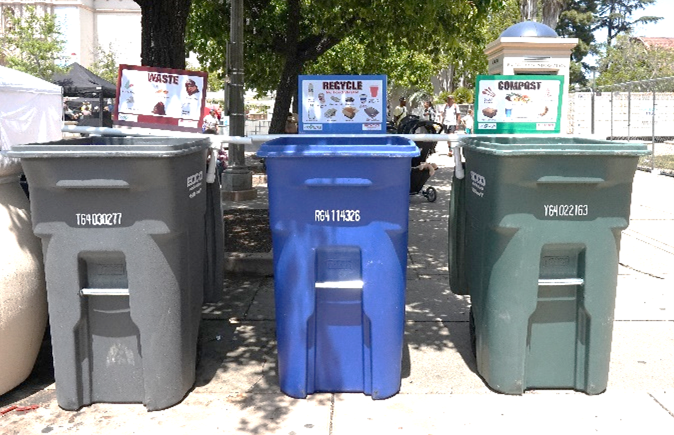three bins with signs