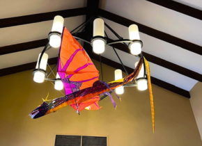 Picture of a dragon kite hanging from a chandelier at the La Jolla/Riford Library