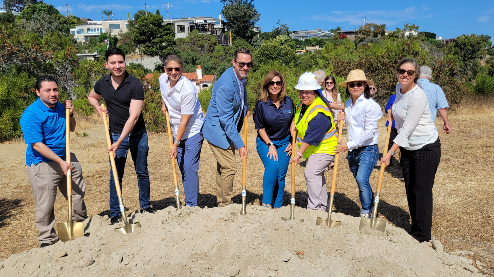group of people posing with shovels at a groundbreaking event
