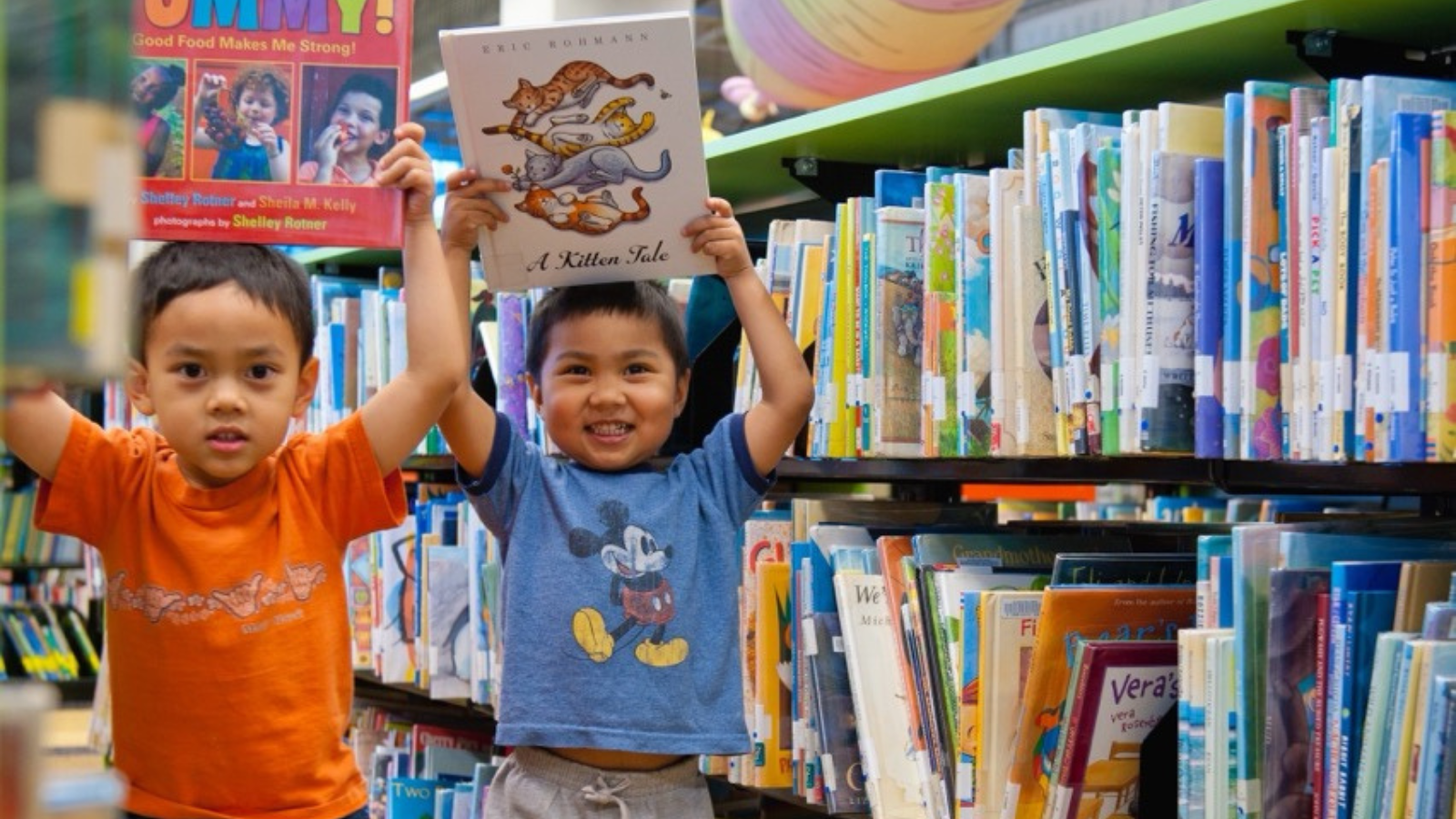 kids holding books in library