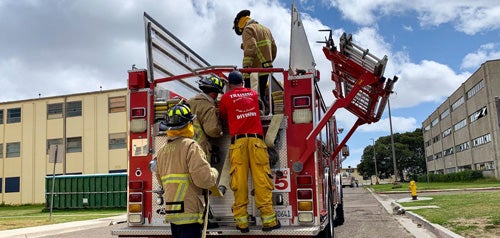 Firefighters inspecting equipment in a fire truck 