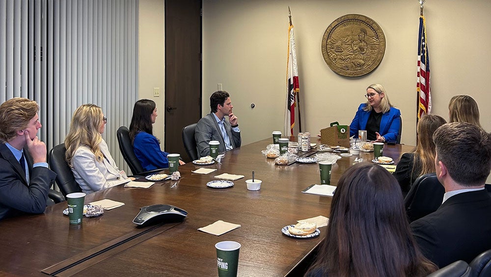 City Attorney Heather Ferbert meeting with staffmembers in a conference room.