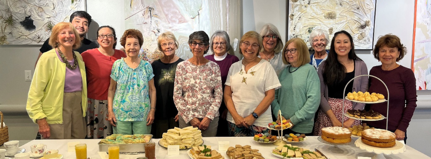 Group of volunteers smiling at the camera behind a table of refreshments