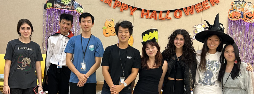 Group of Teens smiling at the camera in front of Halloween decorations