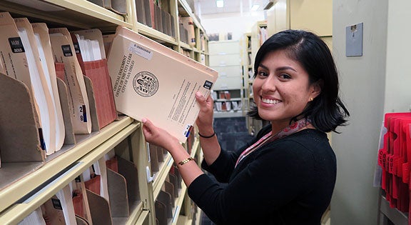 Staff member pulling files from cabinet