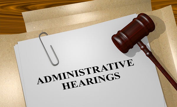 A gavel on top of a paper with the title Administrative Hearings