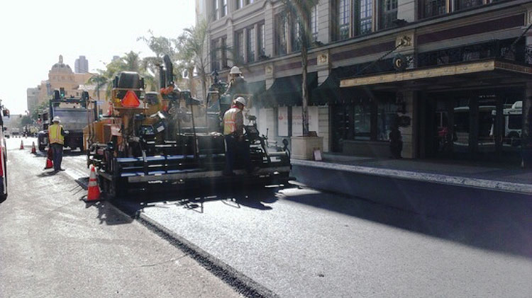 Street Division crew resurfacing the asphalt on a downtown street.
