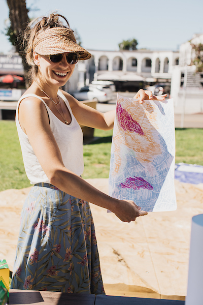 An artist displaying her drawing
