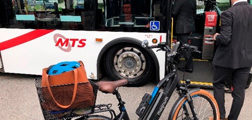 bike parked on sidewalk in front of bus