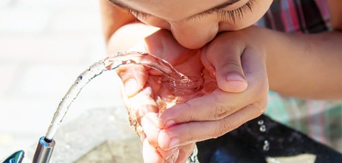 Child drinking from a water fountain