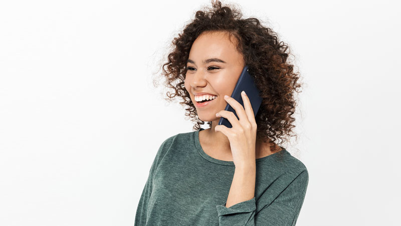 Cheerful casual girl talking on mobile phone
