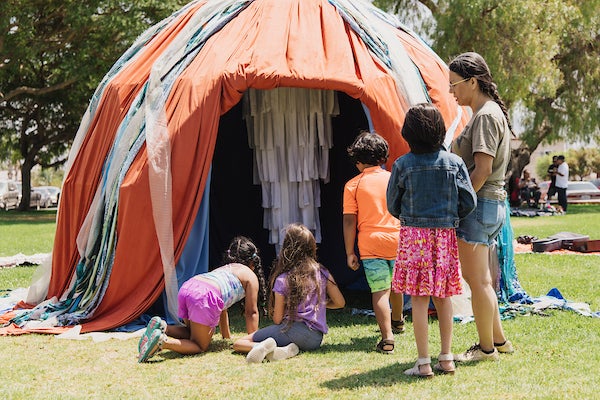 Park visitors entering a colorful dome structure