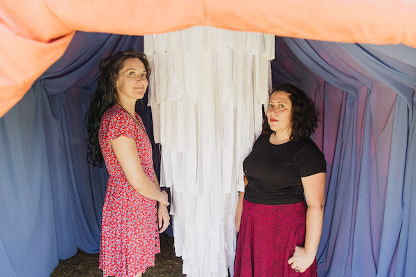 Sheena Rae Dowling and Yvette Roman standing inside a colorful dome structure