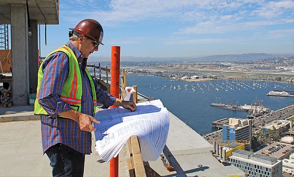 Building inspector looking at plans on top of the Central Library construction site