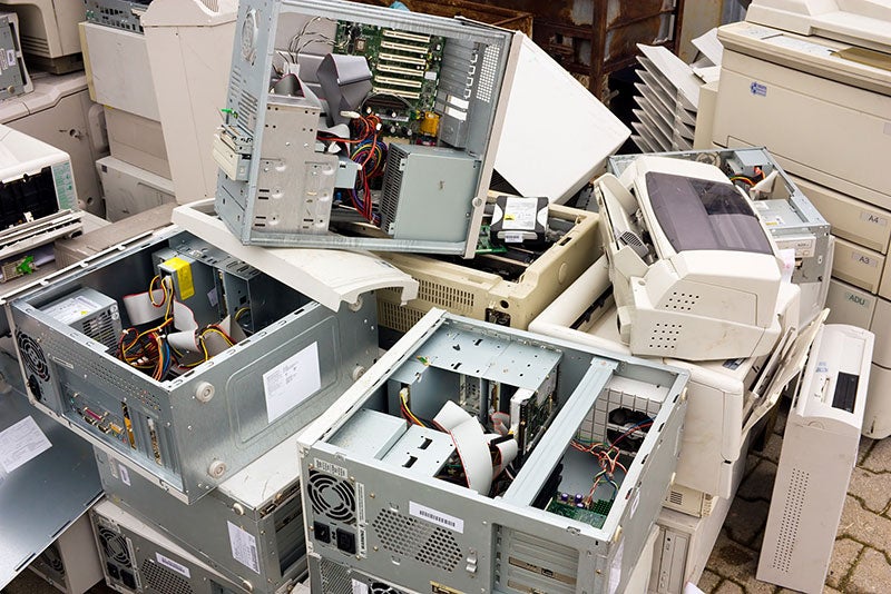 Computers and printer stacked for disposal