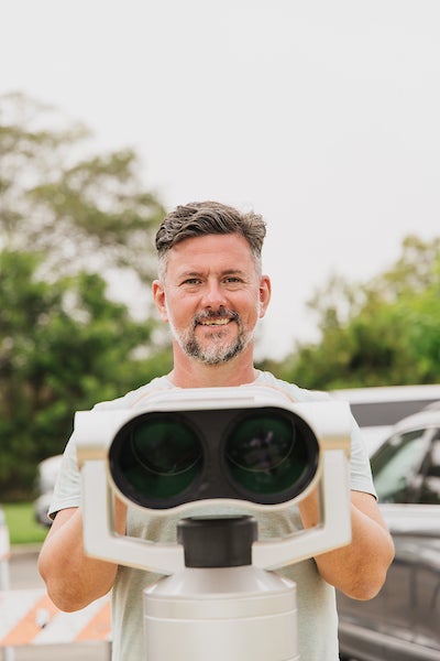 David White presenting one of the binoculars that display video vignettes of everyday workers who make the city of San Diego run