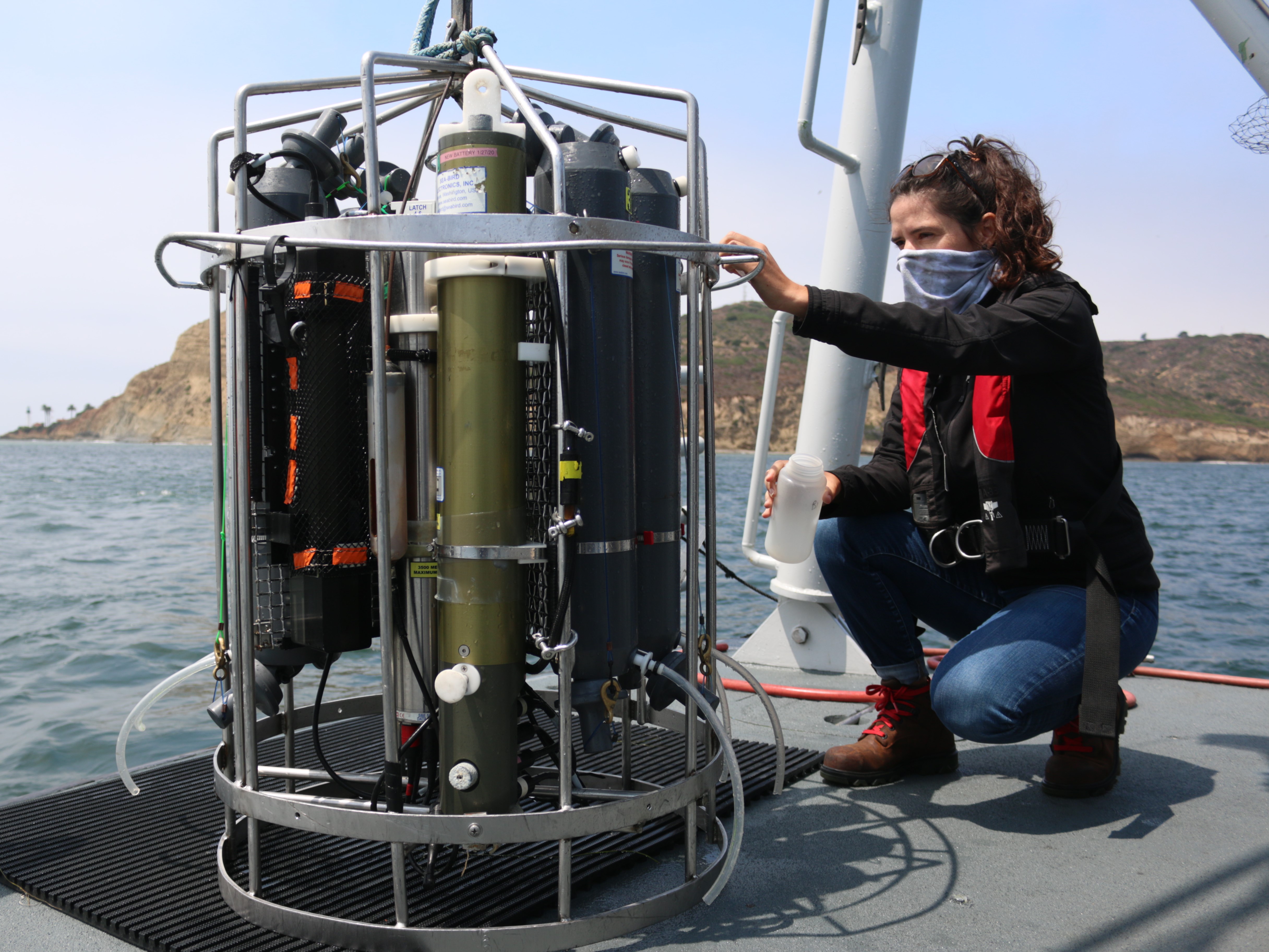 A marine biologist collects a water sample from the conductivity temperature depth profiler, also known as a CTD.