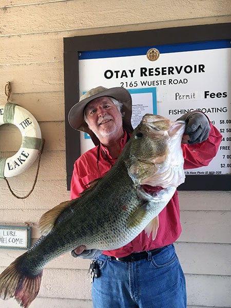 Angler displaying fish caught at reservoir lake