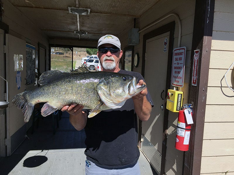 Angler displaying fish caught at reservoir lake