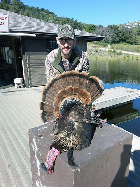 Hunter displaying turkey caught at reservoir lake