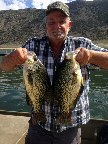 Angler displaying fish caught at reservoir lake