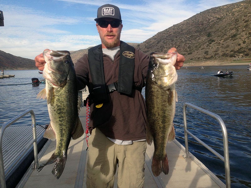 Angler displaying fish caught at reservoir lake