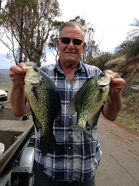 Angler displaying fish caught at reservoir lake