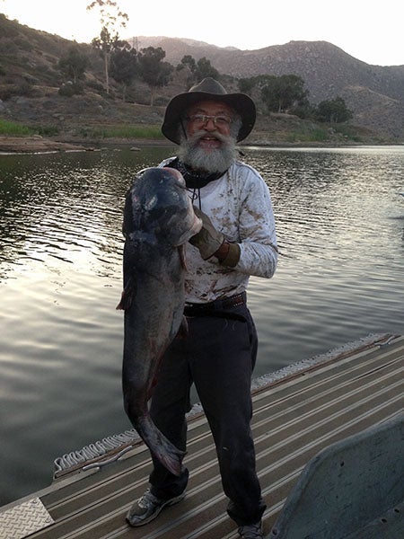 Angler displaying fish caught at reservoir lake