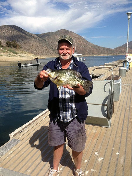 Angler displaying fish caught at reservoir lake