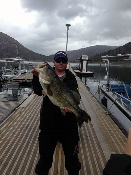 Angler displaying fish caught at reservoir lake