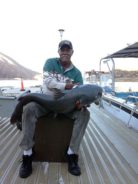 Angler displaying fish caught at reservoir lake