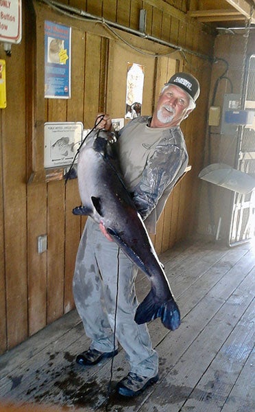 Angler displaying fish caught at reservoir lake