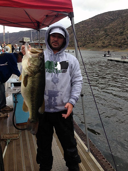 Angler displaying fish caught at reservoir lake