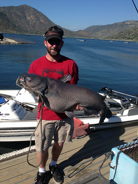 Angler displaying fish caught at reservoir lake