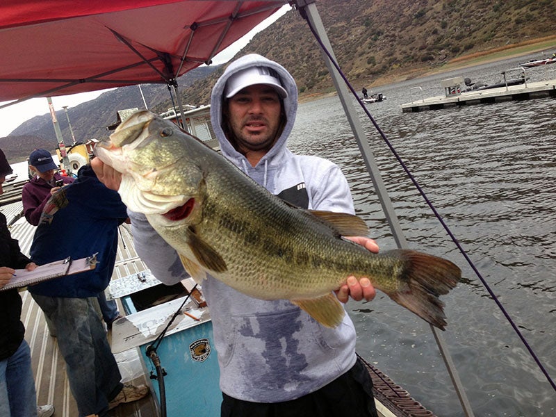 Angler displaying fish caught at reservoir lake